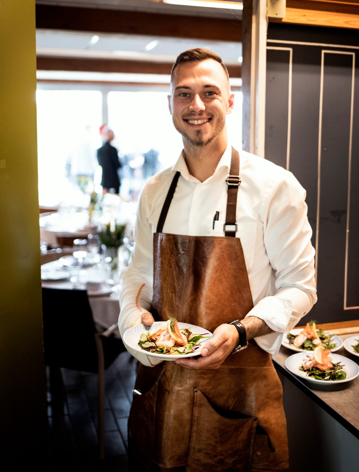 Lächelnder Kellner serviert ein Gericht im Restaurant